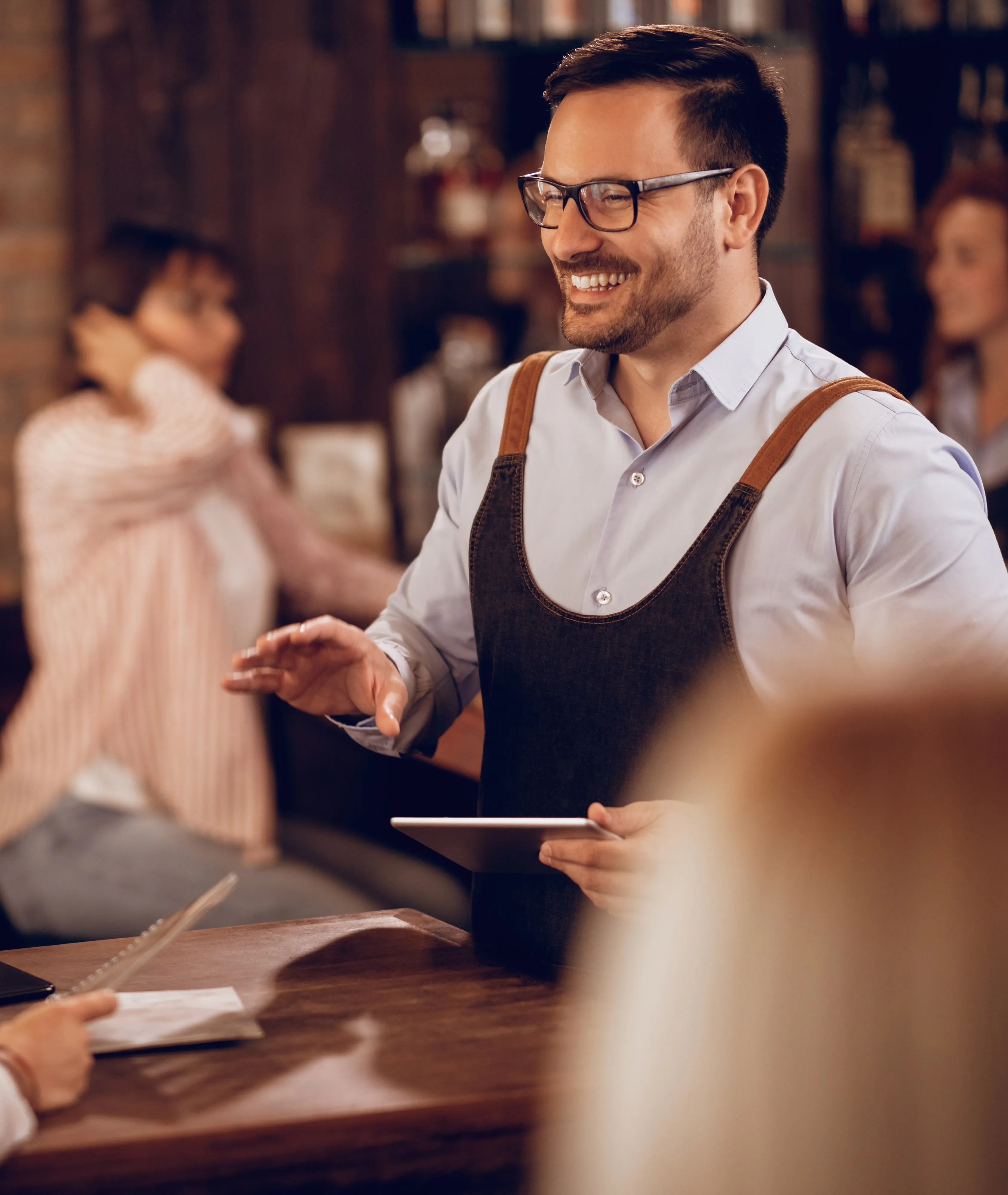 Kellner nutzt ein Tablet zur Reservierungsverwaltung im Restaurant